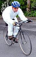 Jason Addy cycling wearing a full white protective overall