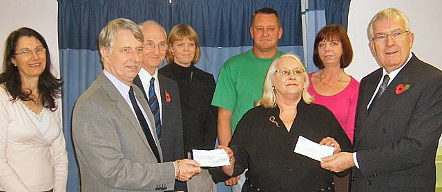 Members of the freemasons hand over cheques to a representative from the Moorland Children's Home.