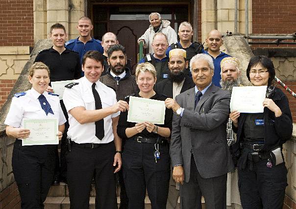 Chief Inspector James Troisi along with town magistrate Ghulam Rasool Shazad who taught the class and Mushtaq Ahmed, chairman of Rochdale Council of Mosques presenting the 12 police officers and police community support officers (PCSOs) from the Kingsway and Milkstone and Deeplish wards with the awards 
