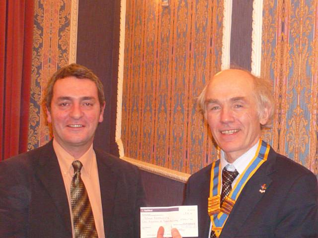 Dennis Skelton receives a cheque from President Elvet Smith of the Rotary Club.