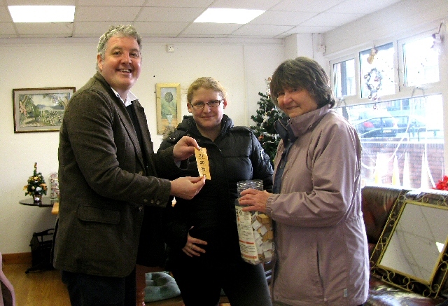 Dale Mulgrew pulling out the winning ticket alongside Margaret Jones from Health Aid UK and Kim Morrisey who was invited to be a witness to the draw