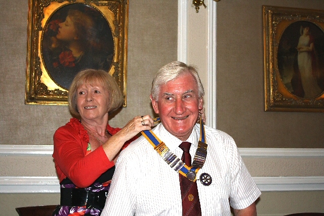 Outgoing president Janice Powell handing over the Rotary chain to John Brooker