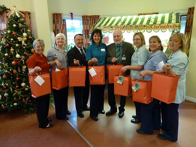 Kenneth Davies, MBE, and Bernard Percy from the Rochdale Freemasons presenting the gifts to some of the Day Care staff at Springhill Hospice
