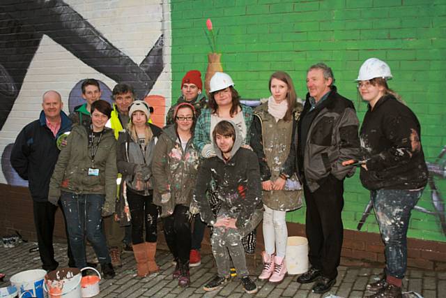 The artwork in progress and the artist with those involved; (back row) Mike Simpson, Programme Manager for Arts & Performing Arts; Luke McDaid from Littleborough; Garry Lavin, part time tutor at the College, artist and TV presenter; Joe Foster, Rachel Whittington, Katie Lennon, Walter Kershaw, Jess Wild, (front row) Beth Grundy, Chelsea Moore, Jeigar Stead, Tom Dodgson