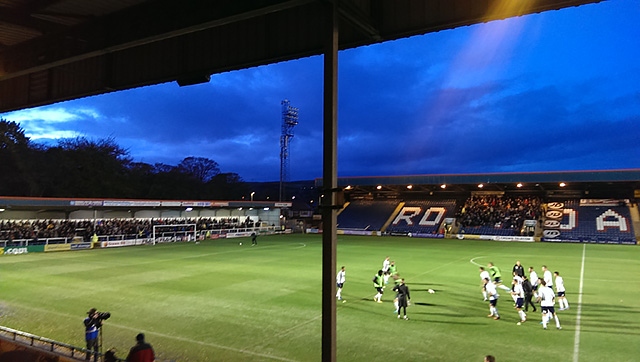 The players warm up as the floodlights return albeit with just three floodlight towers working