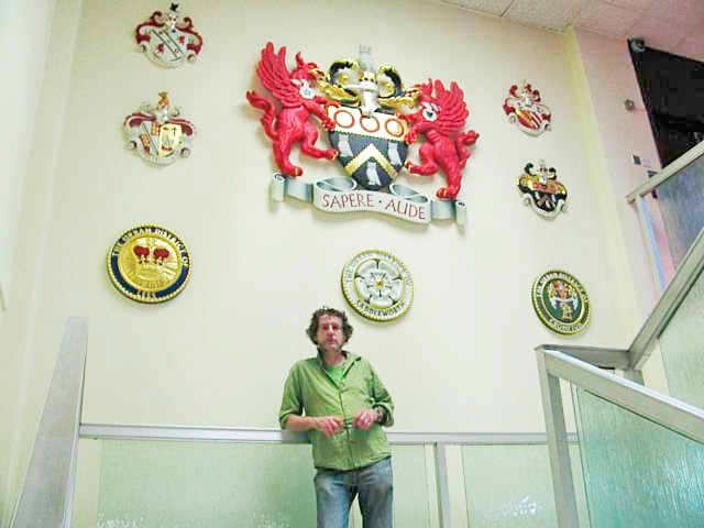 Charlie Oldham with the Oldham Coats of Arms displayed outside the Council Chamber