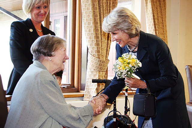 The Duchess of Gloucester accepts flowers from Margaret Geoghegan MBE – the President of Springhill Hospice