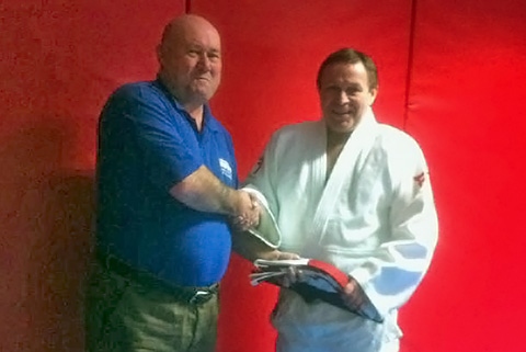 Dave Duffy presented with red and white sixth Dan belt