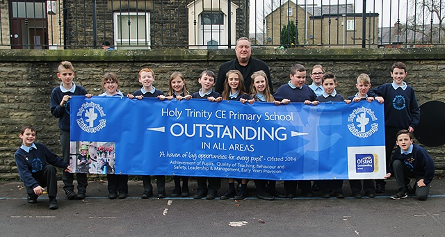 Holy Trinity CE Primary School Head Teacher Mark Kenyon with pupils after their outstanding OFSTED result