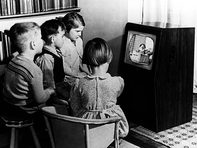 Children gathered around a Black and White TV set watching Andy Pandy on the BBC in the 1950's