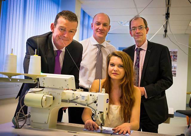 Kerry Travi showing off her sewing skills to Jim Taylor, Rochdale Borough Council’s chief executive, David Moore, managing director of Headen & Quarmby and leader of the council Councillor Colin Lambert 
