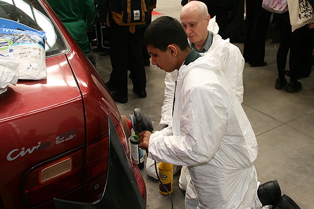 A student gets hands on at the Fix Auto stand