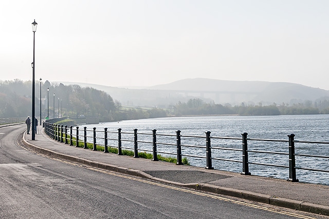 Early morning mist hangs over the distant hills as the sun starts to burn through at Hollingworth Lake before the start of the 5K race and Golden Mile Fun Run