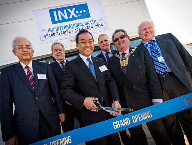 Dr Kotaro Morita, President of Sakata INX and Chairman of INX International Ink Co, is surrounded by INX executives as he performs ribbon-cutting honors to officially open the new manufacturing facility in Heywood