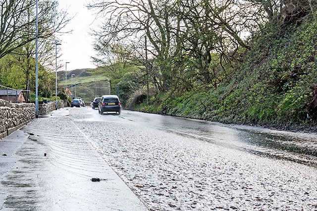 A torrent of water cascading down Huddersfield Road from Ogden to Newhey