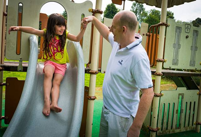 Amy Dawson enjoys the slide with her dad at Rochdale Memorial Gardens
