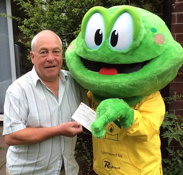 Springy hands a cheque to Mr Owen who won £5,000 in Springhill Hospice’s Summer Bumper draw