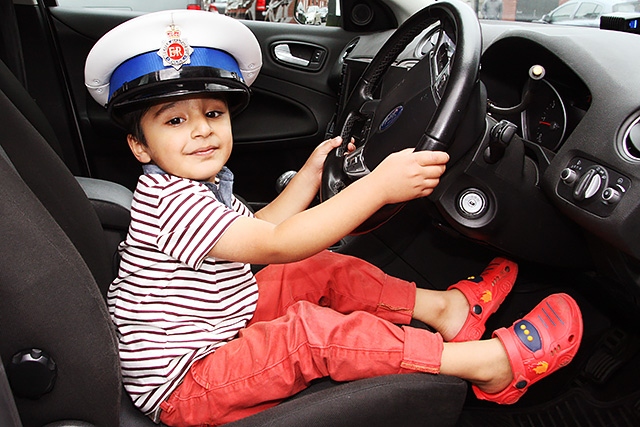 Saad Mehmood enjoys a police car at the Milkstone and Deeplish Community Engagement Day