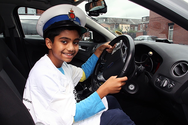 Zakir Habib enjoys a police car at the Milkstone and Deeplish Community Engagement Day