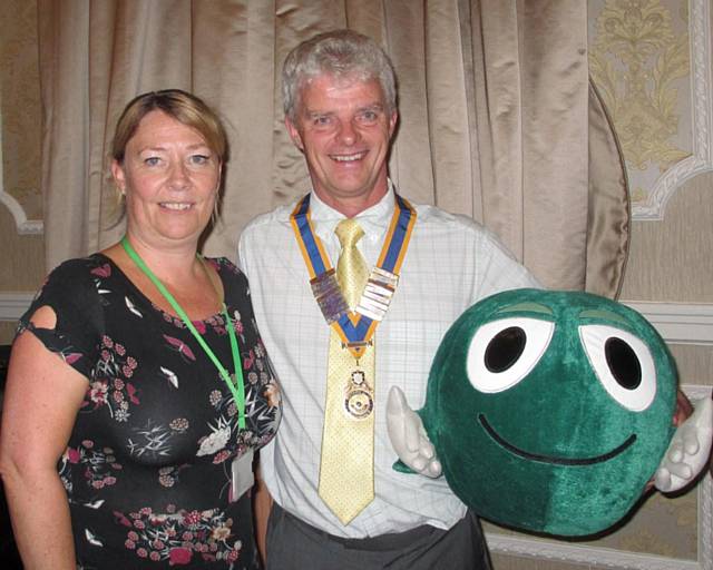 Helen Matthews, the Schools Service Area Coordinator ChildLine North West with the President of the Rotary Club of Rochdale, Bob Chadwick holding Buddy, a large, green, cuddly speech bubble 