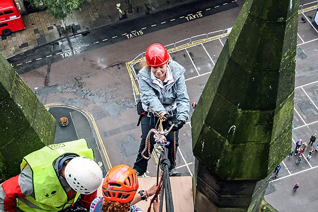 Bride to be Emma Metcalfe starts her 190ft abseil down the town hall clock tower