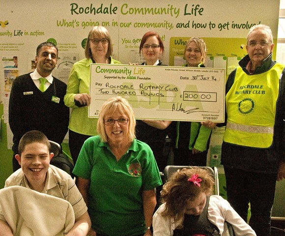 Staff from Asda present a cheque to Rotarian David Acton and staff and students from Redwood School