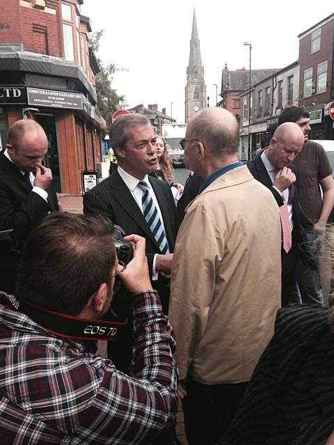 Nigel Farage, chatting to a member of the public on Market Street, Heywood