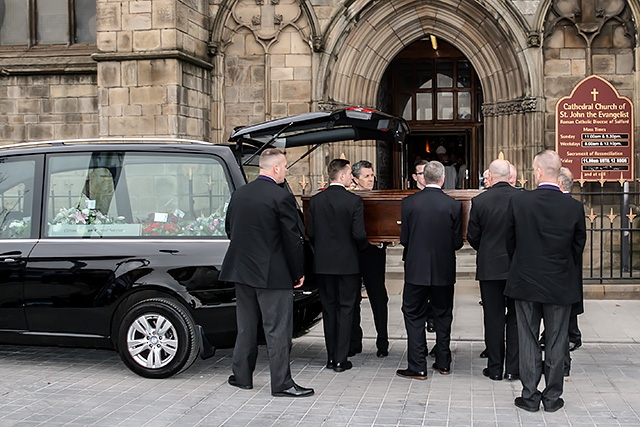 Pallbearers with Jim Dobbin's coffin at Salford Cathedral