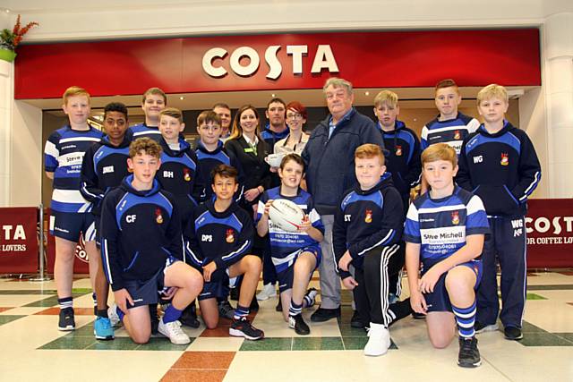 Peter Hoolahan with the Mayfield Mustangs under -12s squad, including his grandson Blake Shepherd-Conwell (boy with dark hair at the front), and team coach Gavin Reynolds, Rochdale Exchange shopping centre administrator Rachel Byrne, and Costa Coffee branch manager Ashleigh Nicholson