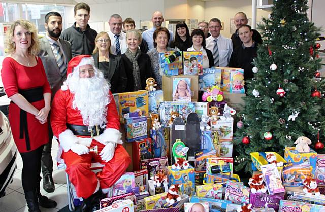 Helen Leach (left) from Rochdale Borough Council meets Father Christmas and the team at Swansway Honda. The company have donated £500 of toys to the council staff run appeal