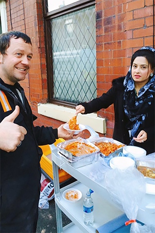 Councillor Shefali Ahmed serving food to one of the volunteers helping with the clean up