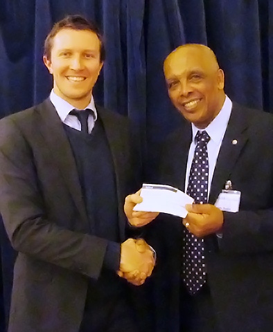 Bobby Cross receiving the cheque from John Holder