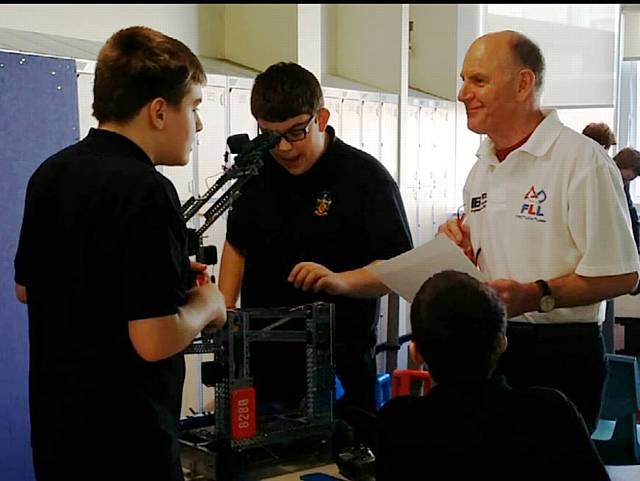 Judge talking to Sam Manton, Karl Ward and Luke Woods at the VEX Robotics competition