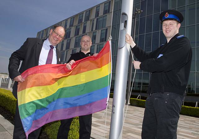 Deputy Police & Crime Commissioner Jim Battle, PCSO Kris Lysaght from the North Manchester Division and Special Constabulary Chief Officer Mike Walmsley raise the flag outside FHQ. 