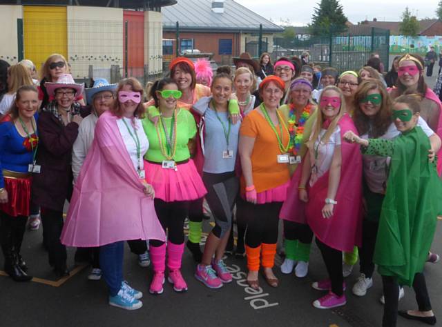 Woodland teacher Paige Roebuck (centre) prepares to put staff and children through their paces for the Macmillan’s ‘Dress up and dance’ day
