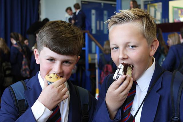 Harrison Smith and Luke Chadwick, both 12, tuck into cakes bought at the Macmillan Coffee Morning at Whitworth Community High School