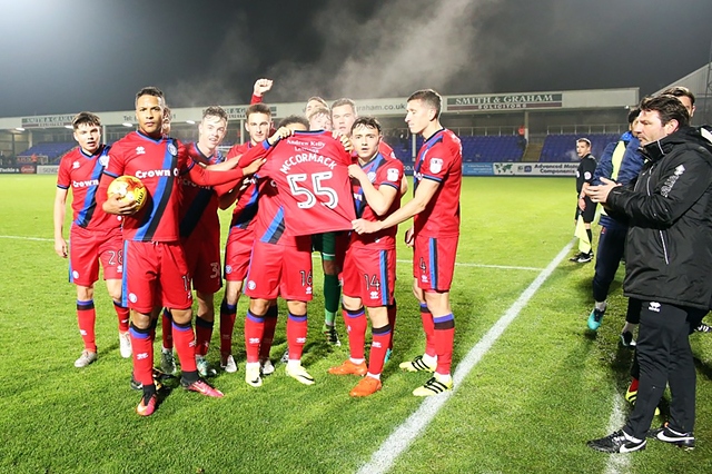 Rochdale players celebrate victory with Joshua McCormack's squad shirt