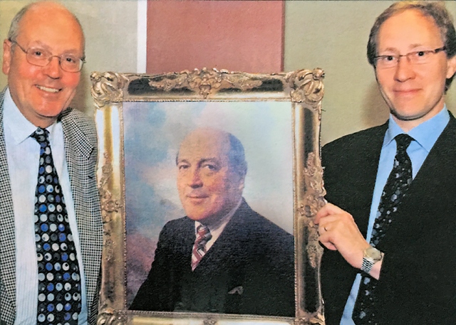 Graham and Nigel Adamson with a painting of Ronald Adamson