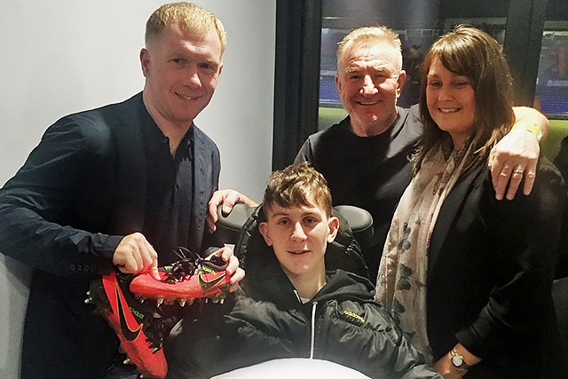 Paul Scholes donates his boots to Ellis Robinson - also pictured are radio DJ Mike Sweeney and Ellis' mum, Lisa