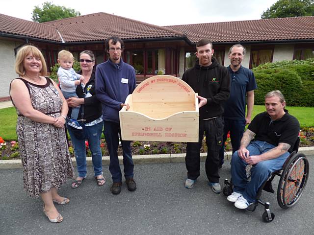 Julie Halliwell, Chief Executive, receives the hand crafted container from Doris Ellison and Benjamin Aughey with Hospice gardener Nick Dent, gardening apprentice Harry Grantham and raffle winner, Gary Rowe