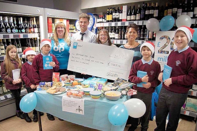 Co-op store manager Ben presents Whittaker Moss Headteacher Melanie Backhouse and Business Manager Dorita Stevenson and some pupils with the cheque