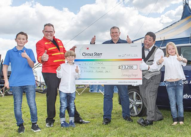 Swansway Group Director David Smyth presenting the cheque assisted by his children, George, Henry and Francesc