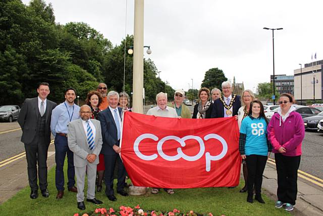 The Co-operative flag being raised outside Rochdale town hall
