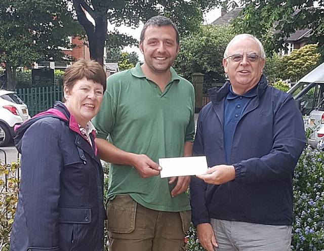 Paul Ellison receiving a cheque towards the equipment from  Councillor Ray Dutton and Elaine Dutton earlier this year