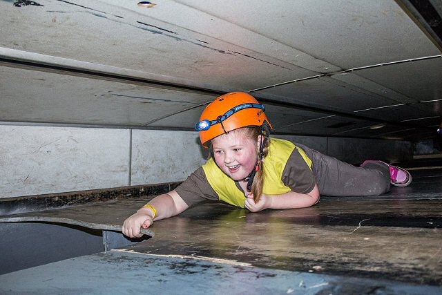 Olivia-Mai Grogan, crawling through the Cave Bus