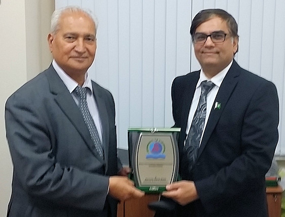 Ghulam Rasul Shahzad was presented with the Plaque of Recognition by Amjad Malik