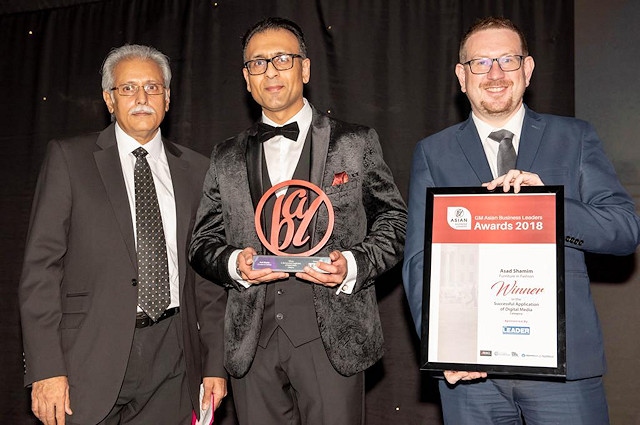 Asad Shamim (centre) is presented with the award by Shadow Secretary of State for Communities and Local Government, Andrew Gwynne MP (right) and Mohammad Pervaiz (left)