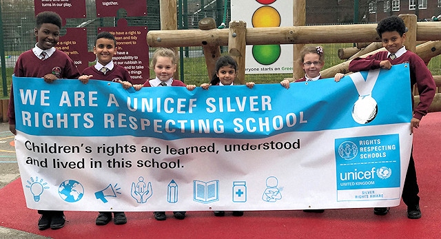 Pupils at Kentmere Primary Academy proudly hold their banner for Silver