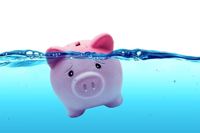 Piggy bank drowning in debt