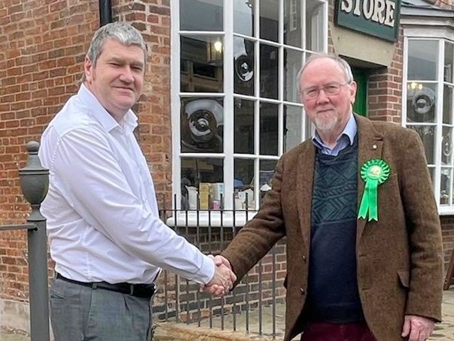 Chris Furlong and Guy Otten, the Green prospective parliamentary candidate for Rochdale, shake hands outside the Toad Lane Co-operative Museum in Rochdale